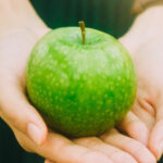 Grönt äpple i händer